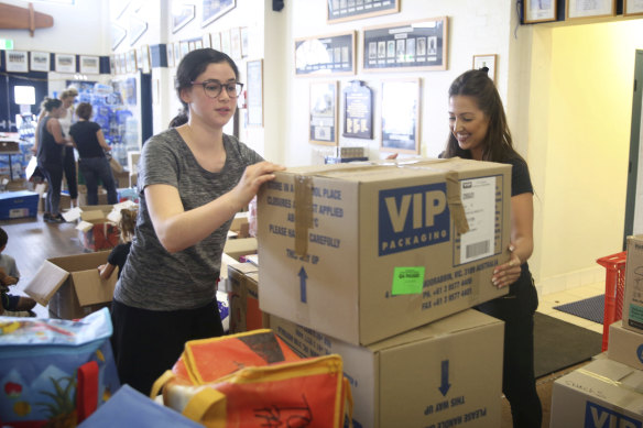 Volunteers and Bondi SLSC members  Leila Freedman and Victoria Nessis prepare donations for delivery.