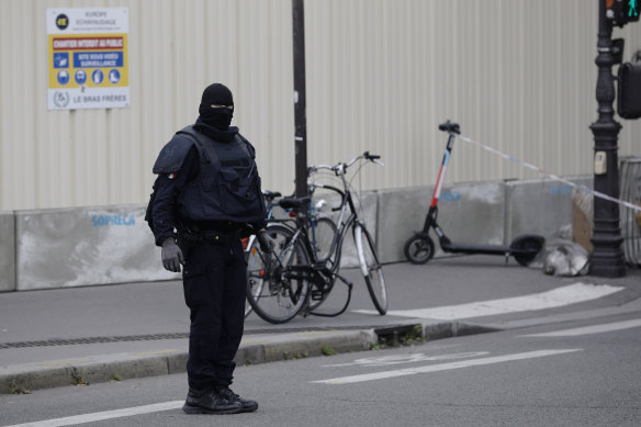 A masked police officer at the scene of a fatal stabbing in Paris.
