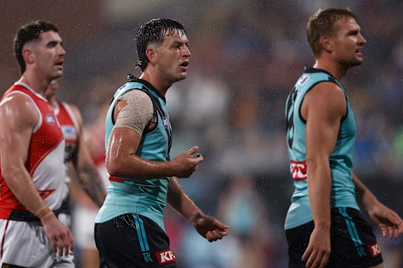 Zak Butters e Ollie Wines ficam confusos depois que um pênalti de 50 metros é concedido contra Port Adelaide. 