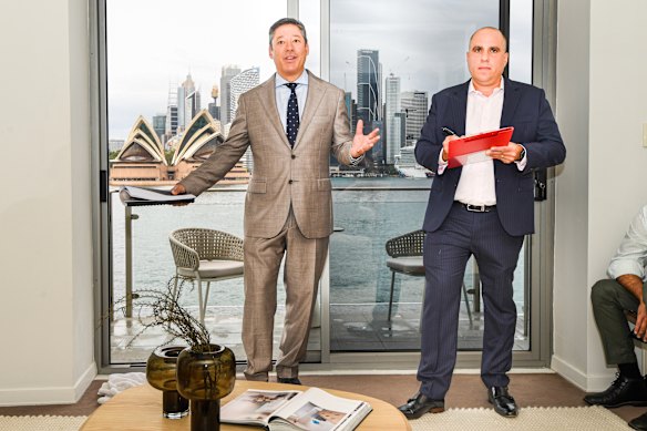 Auctioneer Scott Kennedy-Green (left) and agent Nigel Mukhi at the auction of a two-bedroom apartment in Waruda Road, Kirribilli. And yes, that really is the view.
