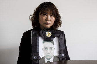 Lihong Wei holds a portrait of her husband, Xiaojun Chen, who was killed while working for a delivery company in Sydney.