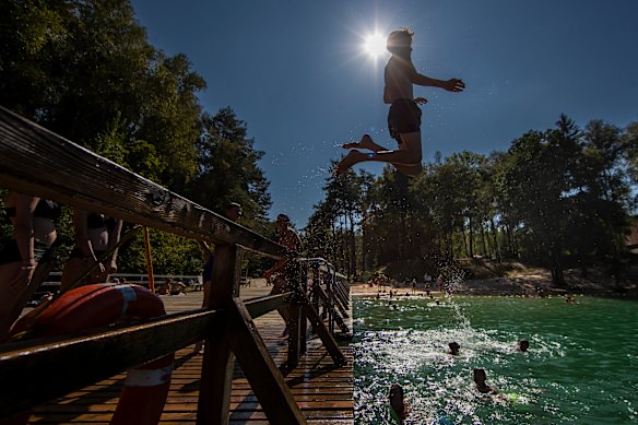 A boy jumps into a lake enjoying warm weather near Vilnius, Lithuania.