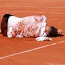 Jakub Mensik collapses after his four-set victory in almost five hours of heat.