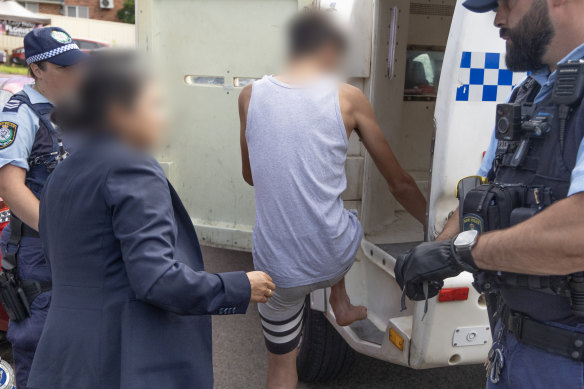 A teenager is arrested in a counter-terrorism raid in Sydney last month.