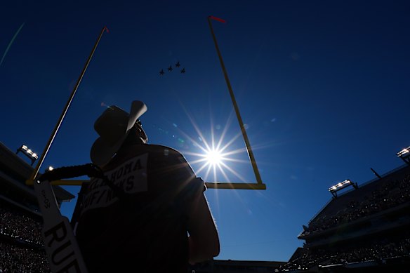 Karsten Stow looks up as F35 fighter jets conduct a flyover above Amon G. Carter Stadium prior to the Armed Forces Bowl NCAA college football game between Navy and Oklahoma in Fort Worth.