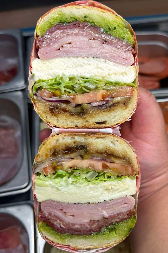 The deli sandwich featuring ham, mild sopressa, prosciutto, fior di latte, onion jam, salsa verde, salad and house pickles. 