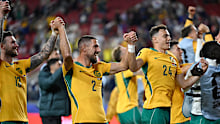Socceroos players celebrate their progression to the Round of 32.
