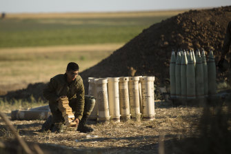 An Israeli soldier works and operates an artillery unit as it fires near the border between Israel and the Gaza Strip on May 18.