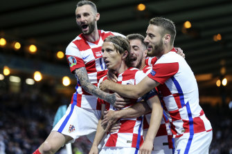 Teammates mob Luka Modric after the Croatia talisman scored his side’s second goal against Scotland.
