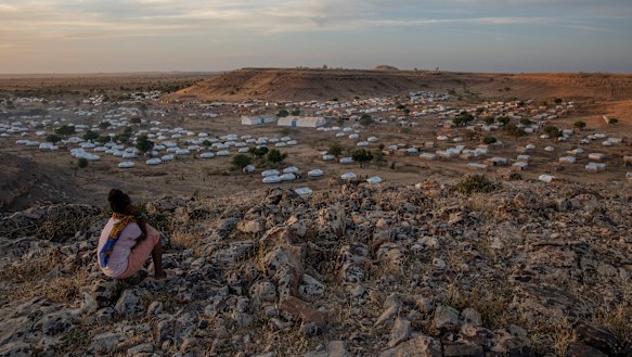 A Tigray girl sits atop a hill overlooking the Umm Rakouba refugee camp, hosting people who fled the conflict in the Tigray region of Ethiopia, in Qadarif, eastern Sudan.