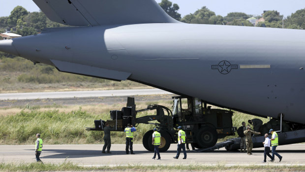A loader disembarks from A United States Air Force C-17 cargo plane loaded with humanitarian aid, after it landed at Camilo Daza airport in Cucuta, Colombia, on Saturday.