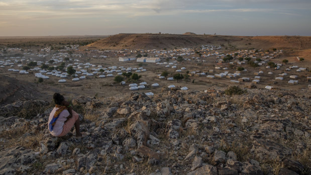 A Tigray girl sits atop a hill overlooking the Umm Rakouba refugee camp, hosting people who fled the conflict in the Tigray region of Ethiopia, in Qadarif, eastern Sudan.