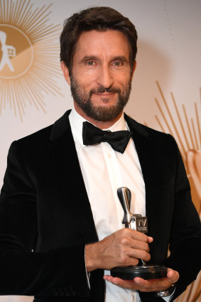 Jonathan LaPaglia, host of Australian Survivor, poses with the Logie for most popular reality program.