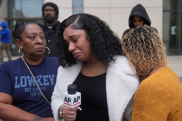 Patrice Williams (middle), who was hosting a party for her daughter where gunfire broke out, is consoled by friends while being interviewed.