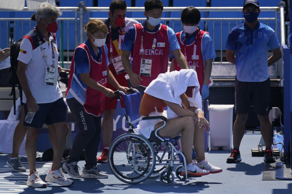 Spain’s Paula Badosa is helped off the court in a wheelchair in Tokyo.