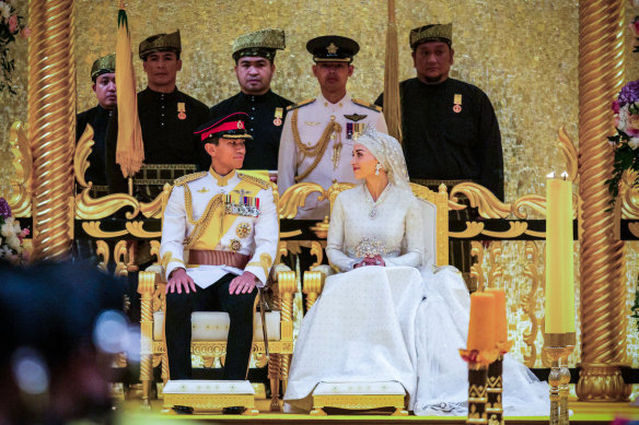 Prince Abdul Mateen and Yang Mulia Anisha Rosnah sit during their wedding reception at Istana Nurul Iman in Brunei’s capital Bandar Seri Begawan.