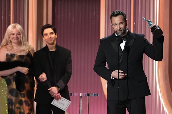 Noah Wyle, right, accepts the award for outstanding performance by a male actor in a drama series for The Pitt, as  Megan Stalter, far left, and Paul W. Downs look on.