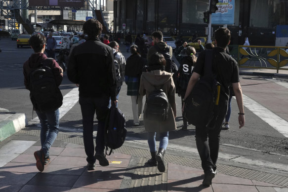 A group of young Iranian women cross a street without wearing their mandatory Islamic headscarves in Tehran, Iran, on November 14.