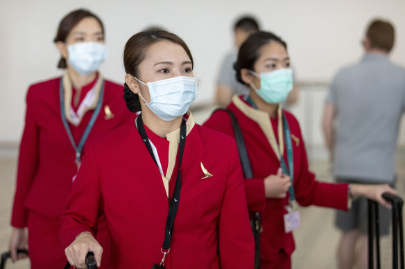 People wearing face masks to protect themselves from coronavirus are seen at Brisbane International Airport.