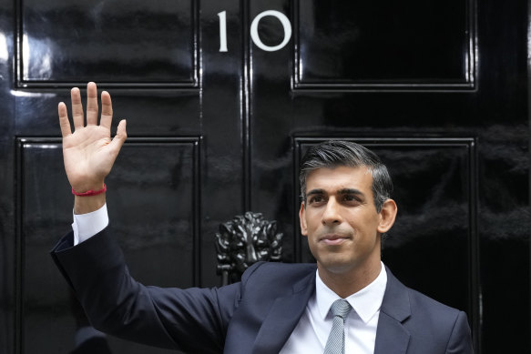 New British Prime Minister Rishi Sunak waves after arriving at Downing Street.