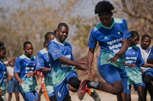 Meninas se aquecem para uma partida de futebol como parte das atividades contra o casamento precoce e a gravidez na adolescência.