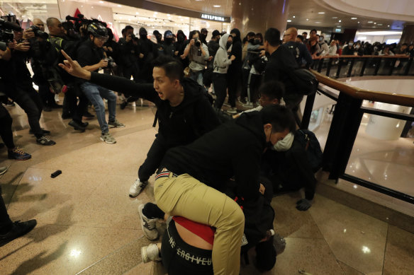 Plainclothes police officers arrest protesters in a mall on Christmas Eve in Hong Kong.