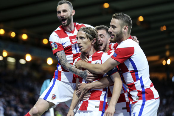 Teammates mob Luka Modric after the Croatia talisman scored his side’s second goal against Scotland.