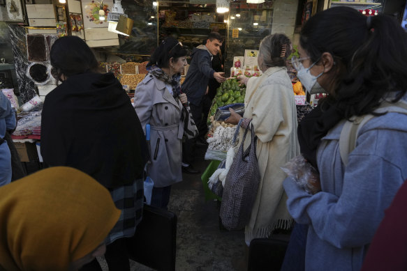 Iranian women conduct their business without wearing their mandatory Islamic headscarves in a commercial district in northern Tehran, in November.