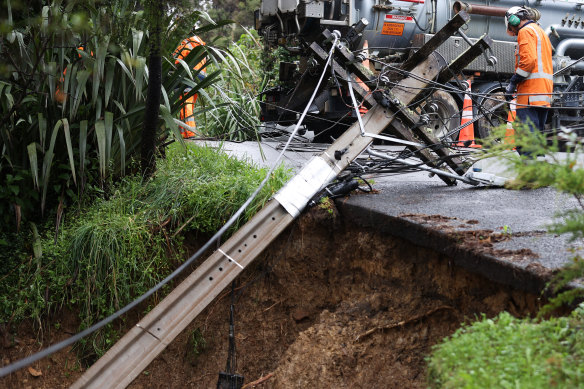Personel, Yeni Zelanda'nın Auckland kentinde bir elektrik direğinin kaymasıyla hasar gördükten sonra hasarı onarmak için çalışıyor. 