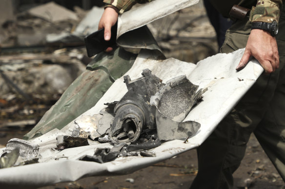 A Ukrainian serviceman carries a part of the missile after Russian attack destroyed the country’s main children’s hospital.