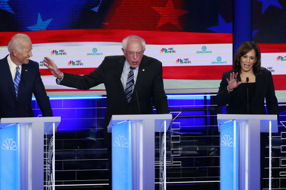 Senator Bernie Sanders, centre, gestures towards Joe Biden as Kamala Harris talks during a debate in 2019.