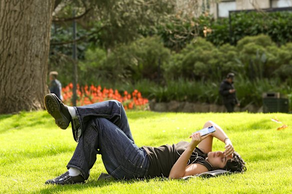 Scarlett Keast basking in the sun on the first day of spring in Fitzroy Gardens.