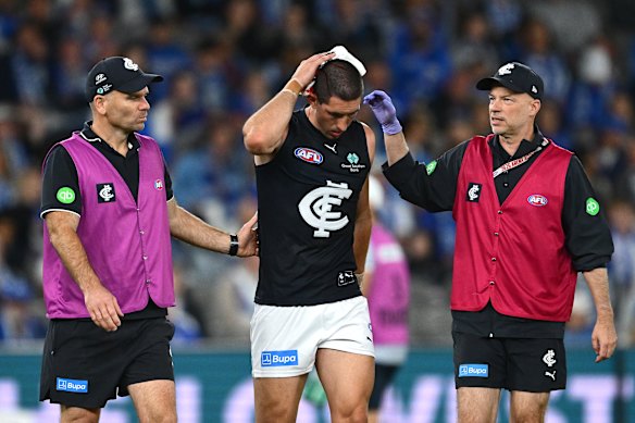 Jacob Weitering of the Blues is helped from the ground by trainers.