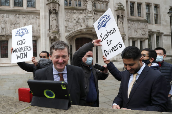 Uber drivers celebrate as they listen to the court decision outside the Supreme Court in London.