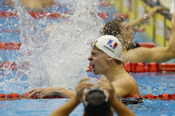 Leon Marchand celebrates after beating the world record.