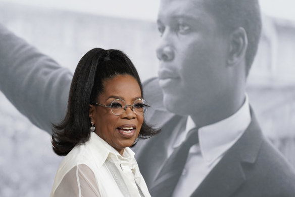 Oprah Winfrey, a producer of Sidney, poses in front of a picture of the film’s subject Sidney Poitier at the premiere of the documentary.
