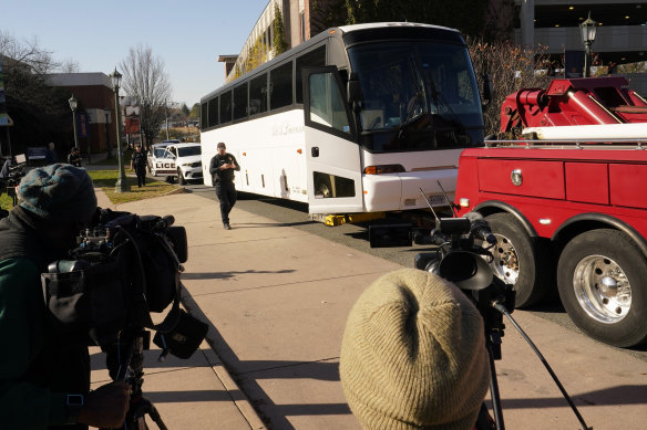 A Virginia State Trooper walks to a tow truck as a bus believed to be the site of an overnight shooting on the grounds of the University of Virginia is hooked up in Charlottesville. Virginia. 