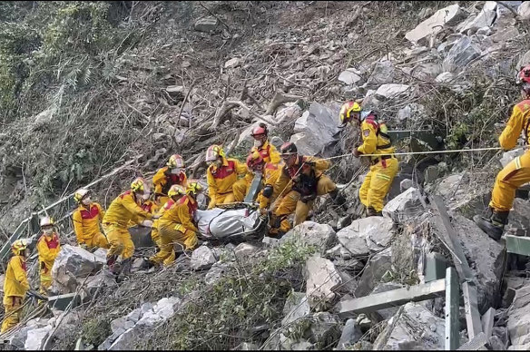 Firefighters evacuate a body from the Taroko National Park a day after a powerful earthquake struck, in the Hualien county, eastern Taiwan. 