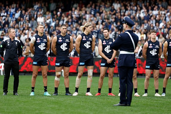 Carlton players look on as The Last Post is played as part of the Anzac round commemorations.