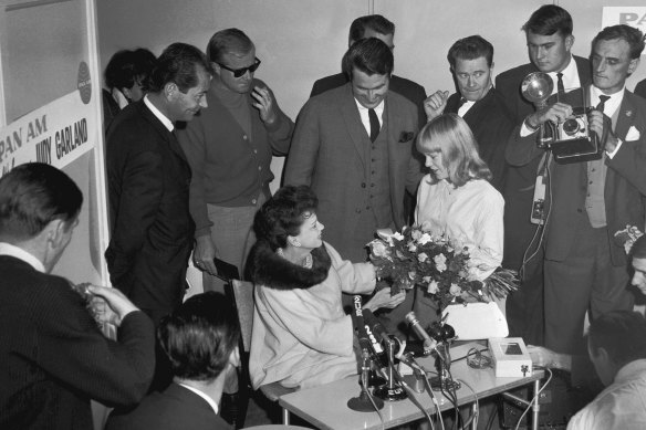 Patricia Amphlett hands Garland a bouquet during her first press conference in Australia. 