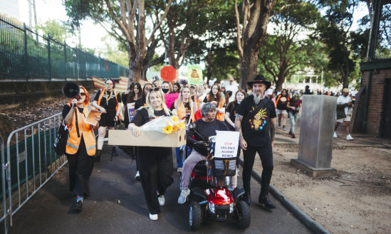 Attendees at the No More: National Rally Against Violence walked past areas fenced off due to asbestos contamination in Belmore Park in Haymarket. 