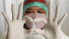 A medical worker shows a bottle of Pfizer COVID-19 vaccine during a third dose vaccination campaign in Indonesia.