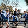 Alphington Grammar School principal  Vivianne Nikou and students in front of the school’s controversial gate across Old Heidelberg Road.