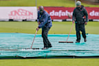 Groundsmen remove water.
