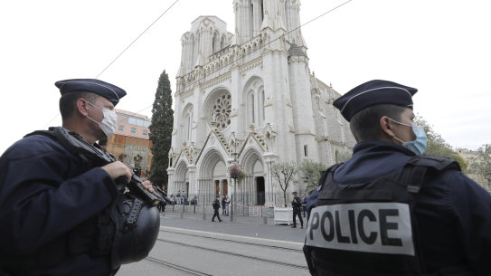 Police officers stand guard near Notre Dame church in Nice after an attacker beheaded a woman and killed two others.