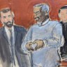 Sean Diddy Combs, center, motions a heart sign to his family in attendance as he is escorted out of lock-up by US Marshals, on the first day of trial, Monday, May 12, 2025, in New York.