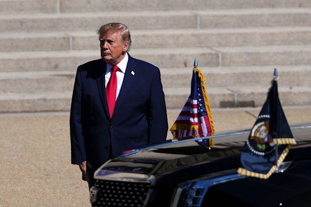 US President Donald Trump waits to greet China’s President Xi Jinping and his wife Peng Liyuan as they arrive at the National Archives Museum