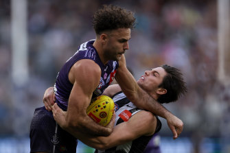 Griffin Logue of the Dockers gets tackled by Oliver Henry of the Magpies.