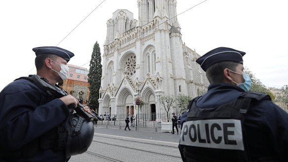 Police officers stand guard near Notre Dame church in Nice after an attacker beheaded a woman and killed two others.