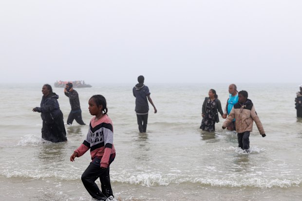 As famílias caminharão para a praia depois de não enviar o barco nos Graelines.